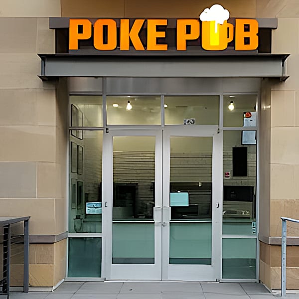 The exterior of Poke Pub, featuring its orange sign with a beer mug icon above glass doors.